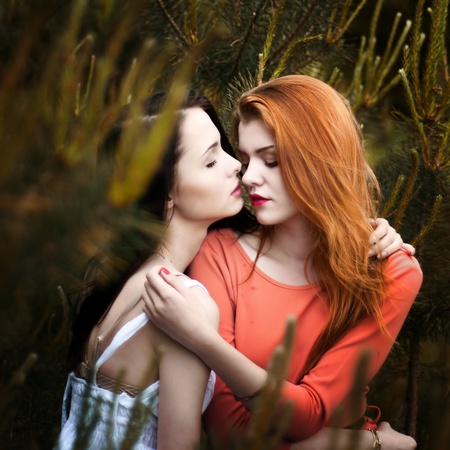 Two beautiful girls in the background of spruce forestの写真素材