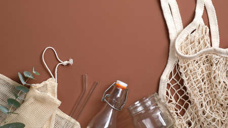 Zero waste concept. Flat lay set of eco friendly shopping bag, glass jar and bottle, metal drinking straws, string bag. Sustainable lifestyle.の写真素材