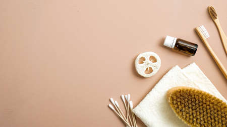 Zero waste bathroom accessories on brown background. Eco friendly ear sticks, bamboo toothbrushes, spa brush, luffa sponge, essential oil, towel. Flat lay, top view, copy space. Plastic free conceptの写真素材
