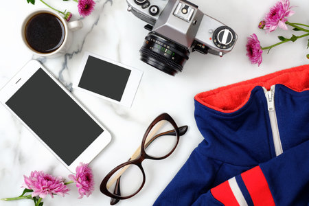 Flat lay home office desk. Female workspace with stylish clothes, glasses, photo camera, phone,...