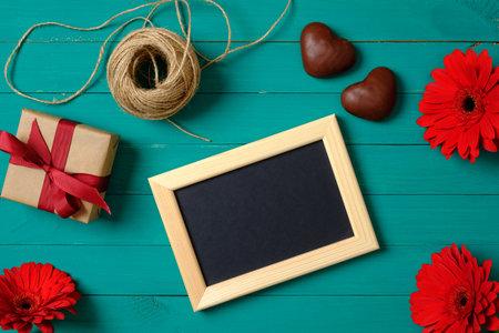 Framework for photo or congratulation, gift box, twine on green background