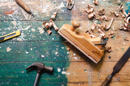Flat lay set of vintage carpentry tools on colorful wooden background. Top view workbench with carpenter different tools. DIY, woodworking, craftsmanship and handwork conceptの写真素材