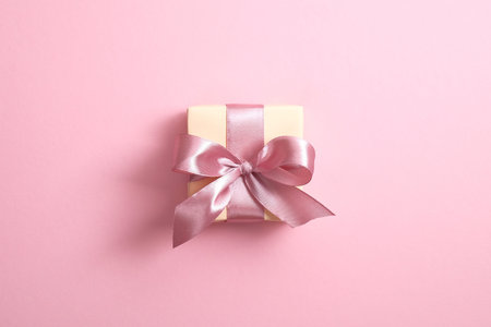 Gift box with ribbon bow on pink background. Elegant, minimal, stylish design. Valentine's,...