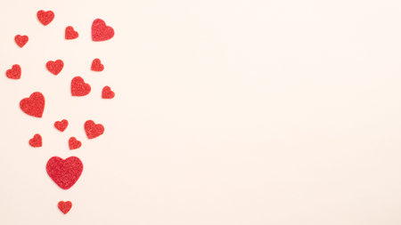 Valentines Day card. Creative layout with red hearts on pastel beige background. Minimal flat lay...