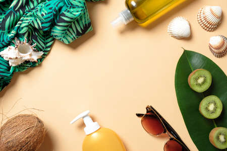 Flat lay elegance woman summer beach accessories on yellow background. Frame with feminine clothes and stuff: sunscreen lotion, fruits, sunglasses, green dress, seashell. Top view. Summer vacation setの写真素材