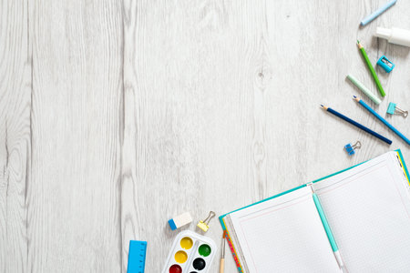School notebook and various stationery on wooden background. Back to school concept. Flat lay, top view, overhead.の写真素材