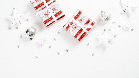 Christmas gifts wrapped red and white craft paper with festive silver decorations on white...