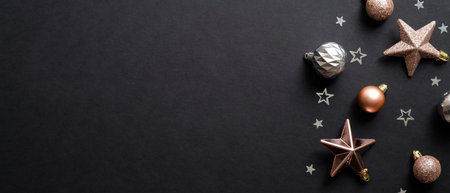 Christmas banner. Black Xmas background with copper color decorations, stars, balls. Christmas frame, New Year greeting card template, winter holiday banner mockup. Flat lay, top view, copy spaceの写真素材