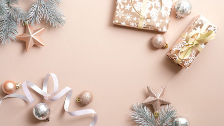 Christmas beige background with gift boxes, pine tree branches, ribbon, Xmas balls. Flat lay, top...