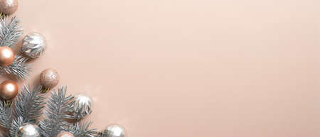 Christmas tree branch with balls on copper background. Xmas frame, luxury New Year banner mockup with copy space, minimal style winter holidays greeting card templateの写真素材