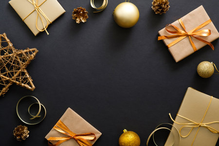 Christmas composition. Christmas frame with golden decorations, gift boxes, baubles on dark black...