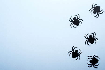 Happy halloween holiday concept. Halloween paper decorations scary spiders on blue background....