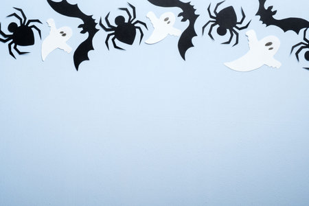 Happy halloween holiday concept. Halloween decorations, spiders, bats, ghosts on blue background. Halloween party greeting card mockup with copy space. Flat lay, top view, overhead.の写真素材