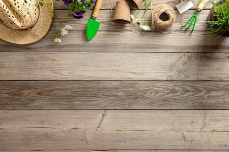Gardening tools and flowers in pots on wooden table. Spring in the garden concept background with free text space (top view, flat lay).の写真素材