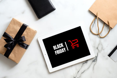 Black friday sale concept. Tablet pad with sign Black friday, gift box, shopping bag on marble...