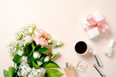 Female workspace with roses flowers bouquet, female accessories, cosmetic, gift box. Flat lay women's office desk. Top view feminine backgroundの写真素材
