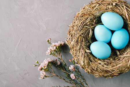 Bird nest with turquoise easter eggs and flowers on gray background.の写真素材