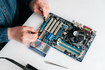 echnician using voltage meter for voltage measurement in computer mainboard. The concept of computer...