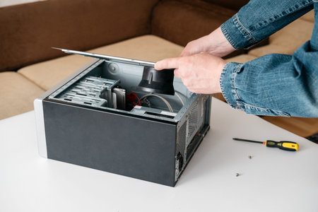 Technician take off part of desktop pc system unit, disassemble computer for repair in service...