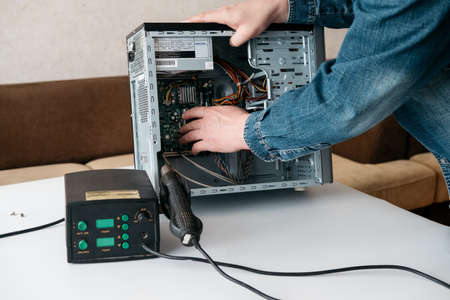 Repairman is disassembling personal computer. Engineer is diagnostic and fixing broken pc in workshop. Electronic repair shop, technology renovation, business, occupation conceptの写真素材