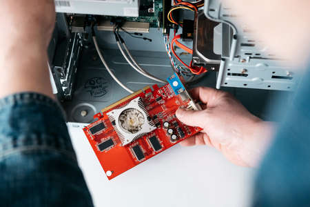 Repairman is take off graphic processing unit from personal computer. Engineer is diagnostic and fixing broken pc in workshop. Electronic repair shop, technology renovation, occupation conceptの写真素材