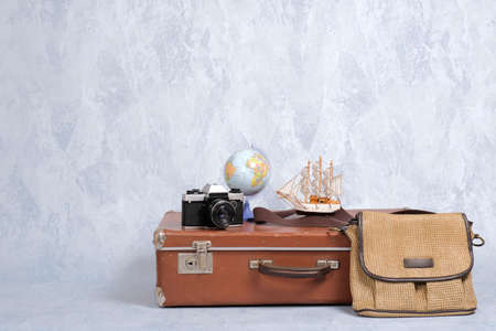 Shabby vintage suitcase with summer marine accessories on gray background. Travel or tourism, summer holiday, vacation concept, banner mockup with copy spaceの写真素材