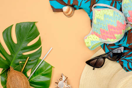 Tropical monstera leaves, coconut, drinking straws, feminine stuff and accessories on yellow background. Summer background, travel vacation, sea resort concept. Banner hero mockup for fashion blogの写真素材