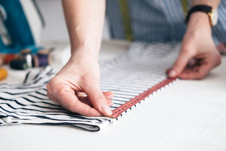 Young woman working with measuring tape in tailor shop