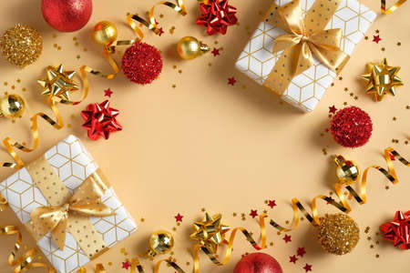 Yellow Christmas background with gift boxes, tinsel, red and golden balls decorations, confetti. Christmas, winter holidays, New Year concept. Flat lay, top view.の写真素材
