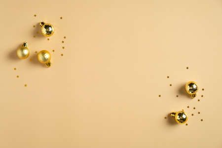 Christmas card mockup. Christmas flat lay composition with golden balls decorations and confetti on pastel yellow background. Top view with copy space.の写真素材