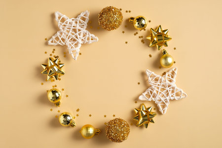 Christmas composition. Christmas wreath made of golden balls decorations, stars, tinsel, confetti on...