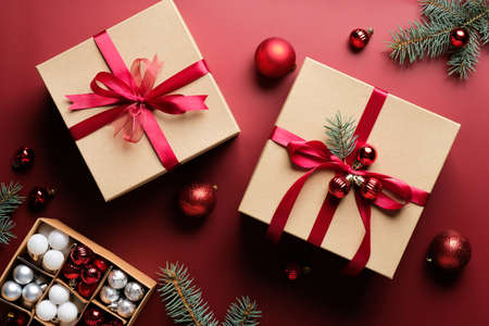 Christmas gift boxes and balls decoration on marsala red background. Flat lay, top view. Christmas, New Year, winter holiday celebration concept.の写真素材