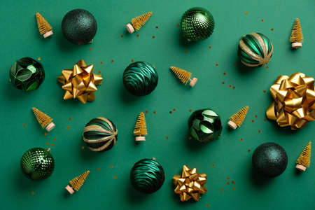 Gold Christmas tree decoration and baubles on green background. Flat lay, top view. Merry christmas cardの写真素材