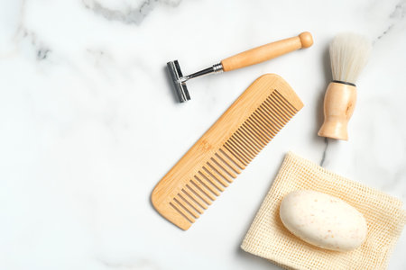 Eco-friendly wooden shaving accessories for man on marble table. Flat lay, top view.