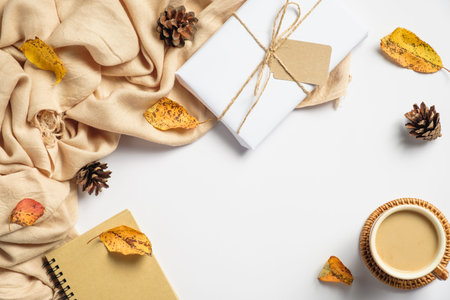 Autumn flat lay composition with beige plaid, gift box, coffee cup, pine cones, fallen leaves on...