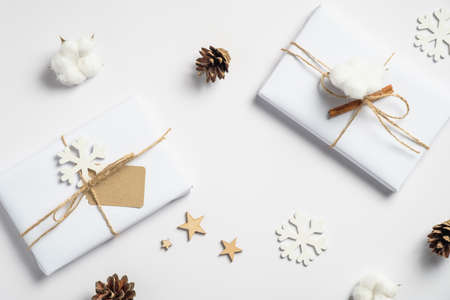 Vintage Christmas flat lay composition with handmade gift boxes, wooden snowflakes and decorations, pine cones on white table. Top view winter holidays, season background.の写真素材
