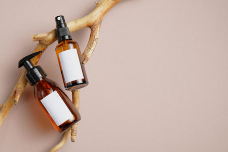 Cosmetics SPA branding mockup. Dark amber glass bottles with white labels for text on wood branch....