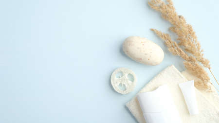 Natural organic SPA cosmetic products set with bath accessories and dry flowers on blue background. Flat lay, top view, minimalist styleの写真素材