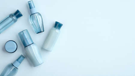 Natural organic SPA cosmetic products set. Flat lay, top view water based skincare beauty products on blue background. Beauty salon banner mockup with hyaluronic acid collagen cosmetics packagesの写真素材