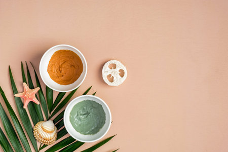 Homemade clay face masks and tropical palm leaf on peach background. SPA natural organic cosmetics...