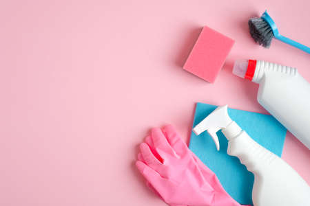 Cleaning supplies on pink background with copy space. House cleaning service and housekeeping concept. Flat lay, top view.の写真素材