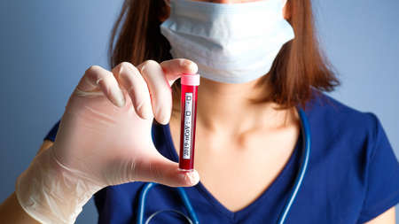 Doctor hand holding test tube with blood for 2019-nCoV analyzing in laboratory. Coronavirus blood test concept.の写真素材