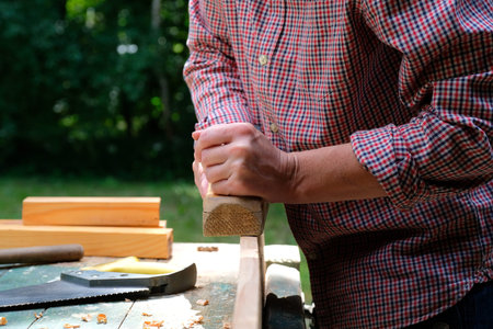 Carpenter woman working with plane outdoors, close-up view. Woodworking concept.