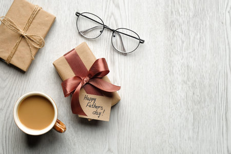 Happy Father's Day concept. Flat lay composition with gift box, cup of coffee, glasses on wooden background. Fathers Day Greeting card template. Top view.の写真素材