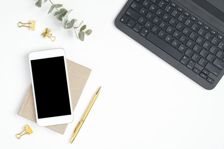 Flat lay, top view office table desk. Minimal workspace with laptop, smartphone, paper notebook,...