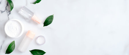 Natural organic cosmetic lotion bottles and hand cream on marble background with green leaves. Flat...