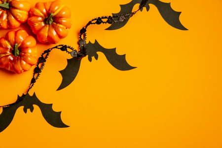 Happy halloween concept. Flat lay composition with halloween decorations, pumpkins, bats on orange background. View from above.の写真素材