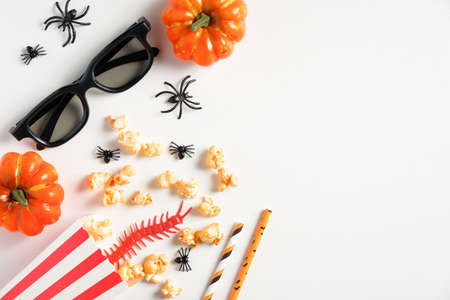 Halloween party decorations on white desk. Flat lay, top view pumpkins, glasses, popcorn, spiders. Halloween background.の写真素材