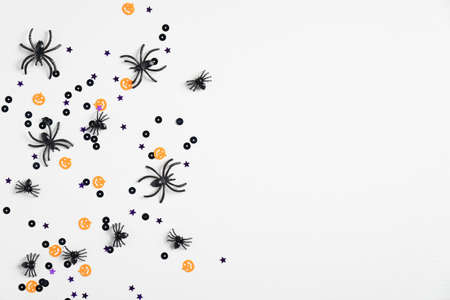 White halloween background with spiders and confetti. Top view with copy space, flat lay. Happy Halloween holiday concept. Halloween sale banner mockupの写真素材