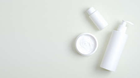 Skincare cosmetic product containers branding mockup. Top view plastic bottle with pump, cream jar, essential oil for hand. Flat lay minimalist style compositionの写真素材